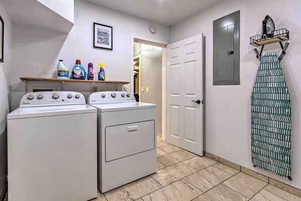 A laundry area with two Whirlpool washers, a shelf with detergent bottles, a door, and a hanging rack. - Deck + Fire Pit: Lakefront Hideaway in Scranton! (Scranton)