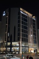 Un moderno edificio de hotel con un letrero llamativo que dice "Royal Plaza Hotel Apartment".