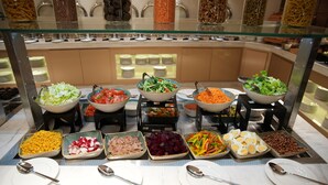 A buffet with various food items and utensils. - Royal Mansoura Residence Hotel (Doha)