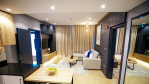 A modern living room with a sofa, coffee table, and a dining area with a table and chairs. - Royal Mansoura Residence Hotel (Doha)