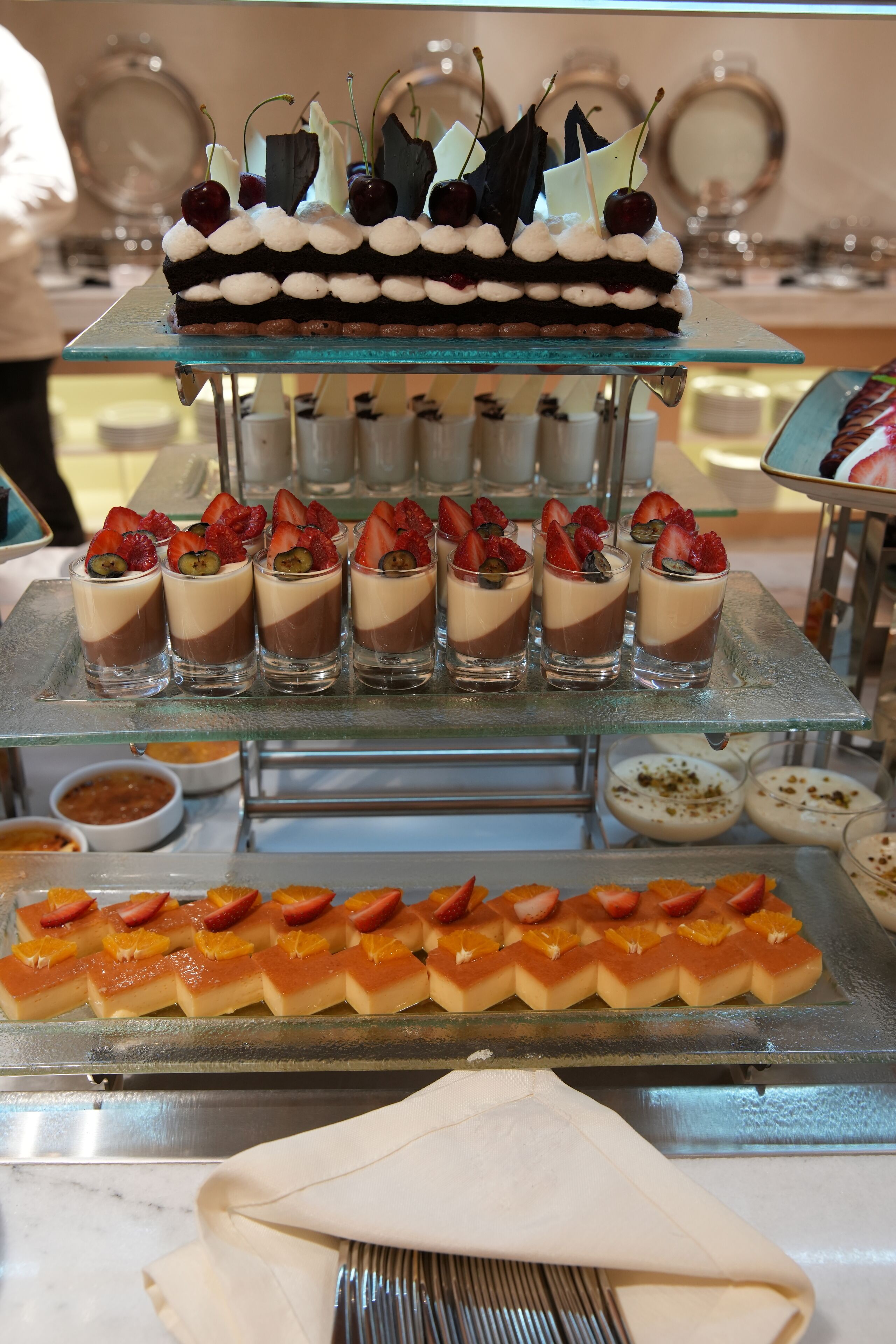 Une présentation de desserts variés sur un présentoir en verre.