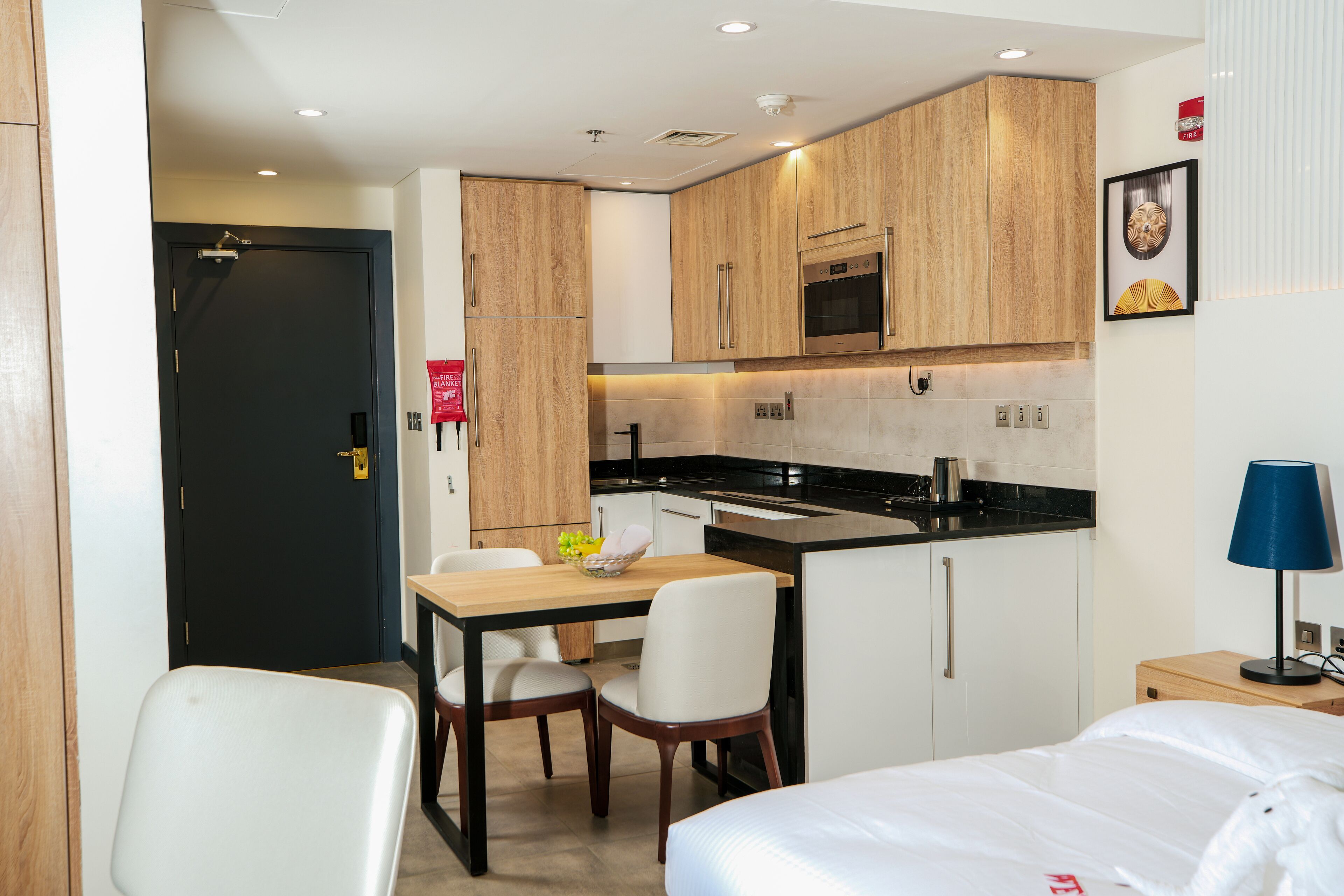 Une chambre d’hôtel compacte comprenant un coin cuisine, un espace repas et un lit.