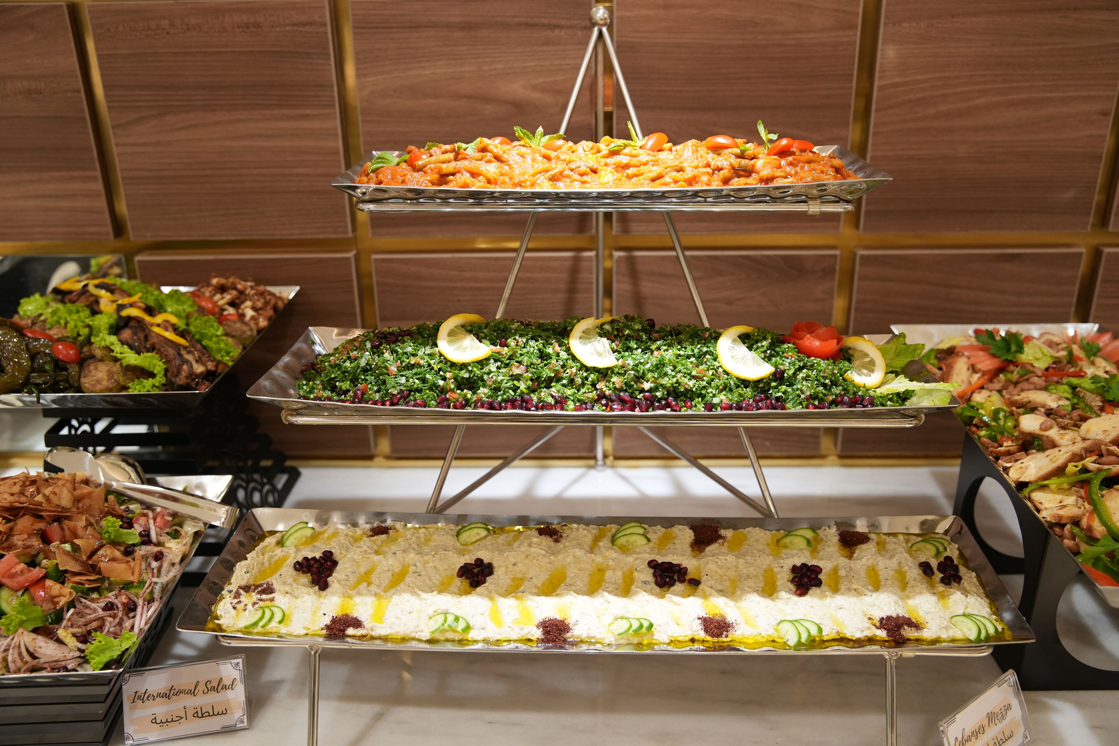 A buffet with various dishes including salads, meats, and a layered dessert.