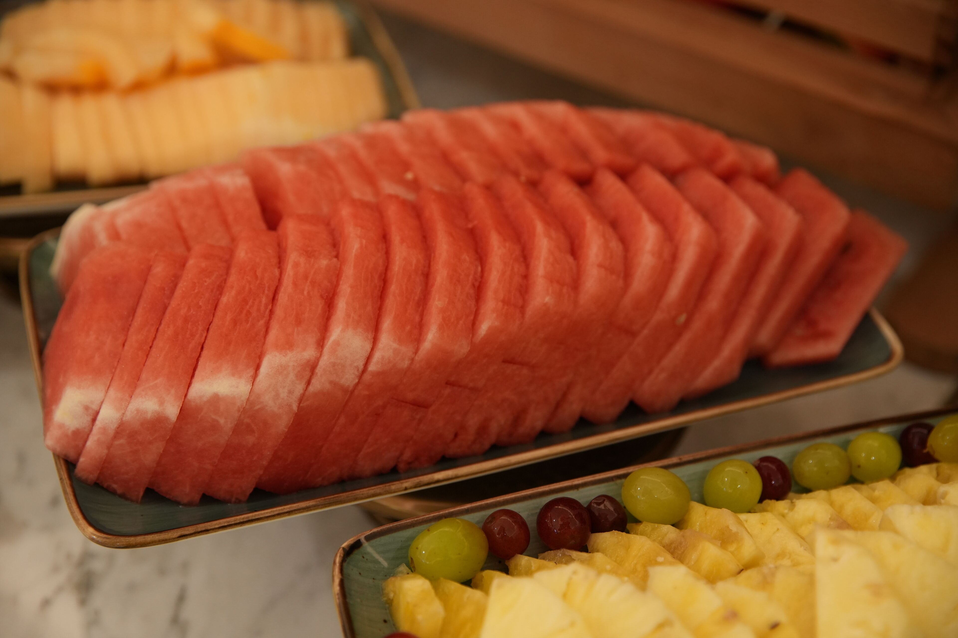 Une assiette de fruits comprenant des tranches de pastèque et des morceaux d’ananas.