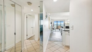 A modern hotel room with a kitchen area, a dining space, and a view of the sea. - XPLORIE ACTIVITIES & LINENS INCLUDED*! Direct Oceanfront 2 bedroom (enclosed den converted to a 3rd bedroom with new double bed & pocket door) 2 bath condo. (Ocean City)