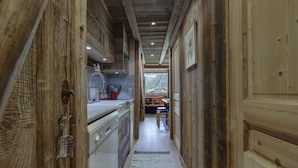 Un pasillo estrecho con paredes de madera y una zona de cocina a un lado.
