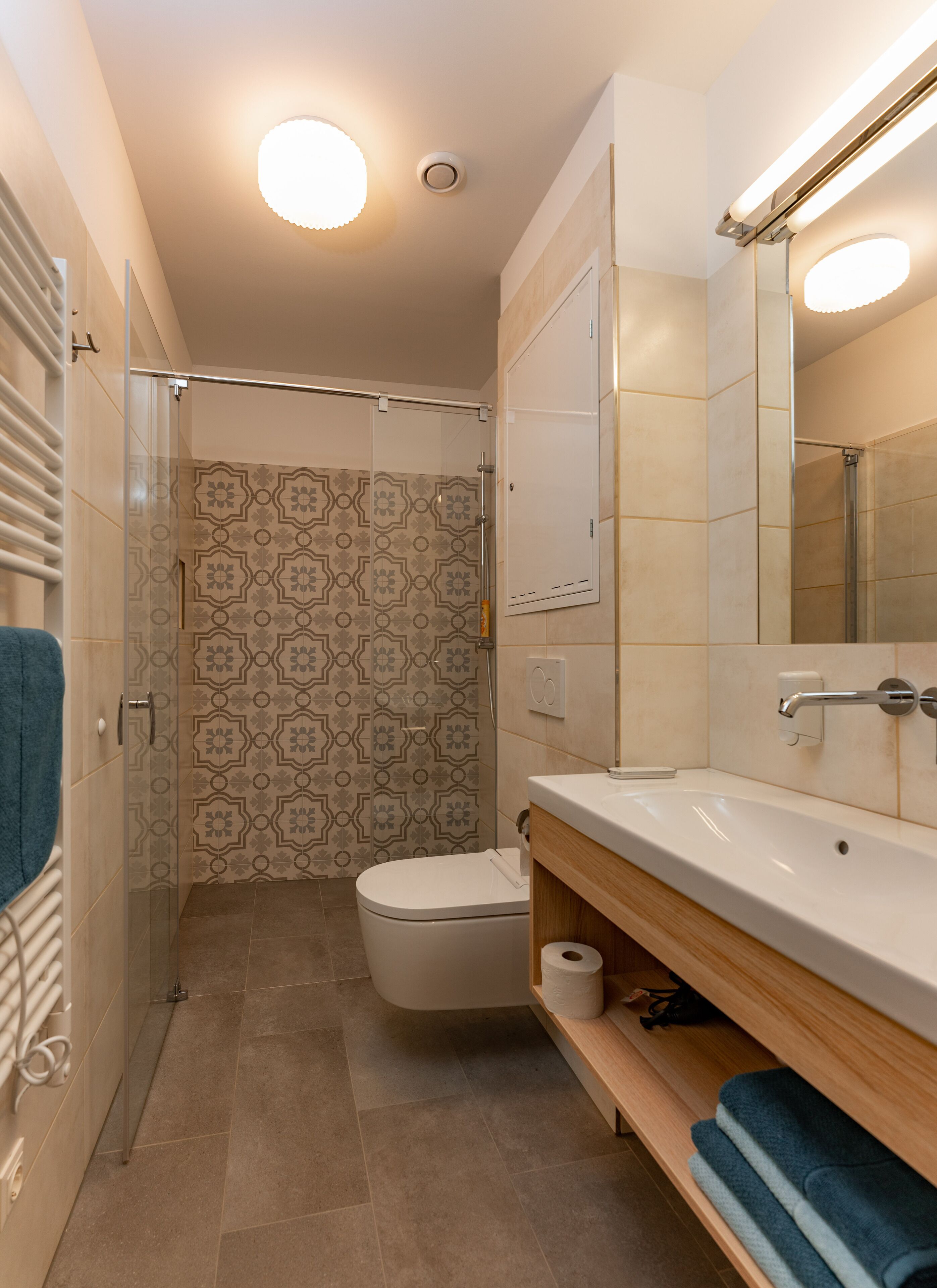 A modern bathroom with a shower, toilet, and sink.