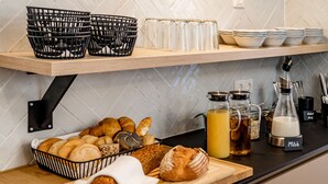 A kitchen counter with bread, a cutting board, and various kitchen items. - Villa Elisa (Salzburg)