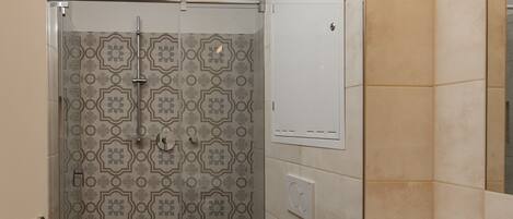 A bathroom with a shower, toilet, and sink.