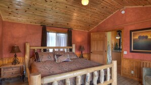 A wooden-framed bed with patterned bedding in a room with wooden walls and ceiling. - Private Hot Tub | Mountain Retreat | ATV's | Close to Wolf Creek Ski Area (South Fork)