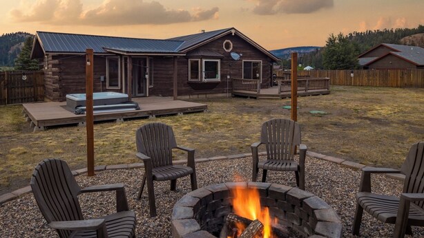 A log cabin with a deck, hot tub, and fire pit. - Private Hot Tub | Mountain Retreat | ATV's | Close to Wolf Creek Ski Area (South Fork)