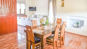 Un comedor con una mesa y sillas de madera, un sofá al fondo y una chimenea.