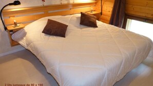 Un dormitorio con una cama grande, dos lámparas de noche y un cabecero de madera.