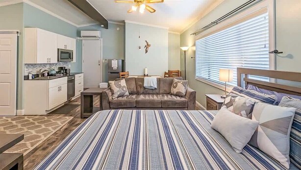 A bedroom with a large bed, a sofa, a dining table, and a kitchen area. - Newly Remodeled Studio w/ AC & Private Entrance (Port Angeles)