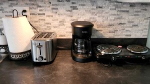 A kitchen with a toaster, a coffee maker, and a stove. - Newly Remodeled Studio w/ AC & Private Entrance (Port Angeles)