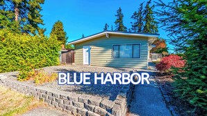 A single-story house with a front door, a small porch, and a garage. - Newly Remodeled Studio w/ AC & Private Entrance (Port Angeles)