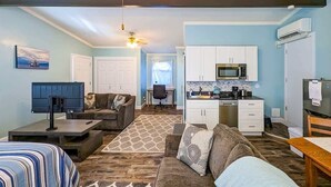 A compact living space with a kitchenette, a sofa, a coffee table, and a TV. - Newly Remodeled Studio w/ AC & Private Entrance (Port Angeles)