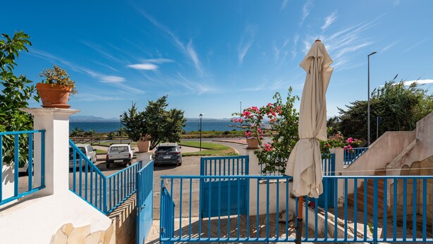 A gated entrance with a view of the sea, a parking area, and a staircase leading to a building. - Holiday Home Casa Vacanze 21 Aprile - T with Sea View & Terraces (Calasetta)