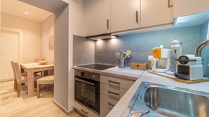 Eine moderne Küche mit Einbauofen, Spüle und Kaffeemaschine.