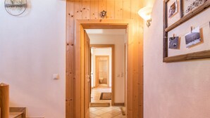 A wooden staircase leading to a room with a tiled floor, a door with a number, and a wall with framed pictures. - Apartment Ciasa Raut App Santa Berbura with Mountain View, Balcony & Wi-Fi (La Val)