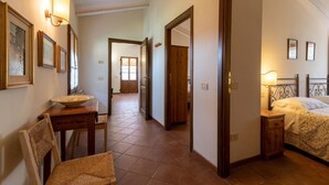 Une chambre d’hôtel avec un lit, une table de chevet, une lampe et une vue sur le couloir.