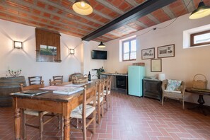 Une cuisine rustique avec une table en bois, des chaises et un sol carrelé.