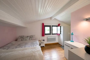 A bedroom with a bed, a desk, a radiator, and a window with curtains. - Villa 8 Personnes Saint Jean de Luz à Pied (Ciboure)