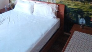 A bed with white bedding, a wooden headboard, and a nightstand with a glass. - Pet-Friendly Apartment 'Casa Rosciano' with Mountain View & Garden (rosciano)