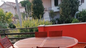 A round wooden table with chairs on a tiled patio. - Pet-Friendly Apartment 'Casa Rosciano' with Mountain View & Garden (rosciano)