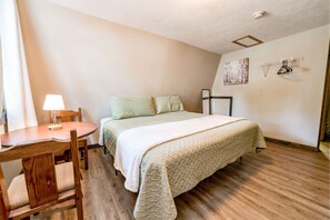 Cozy retreat with a comfortable bed, a small table, and a chair.