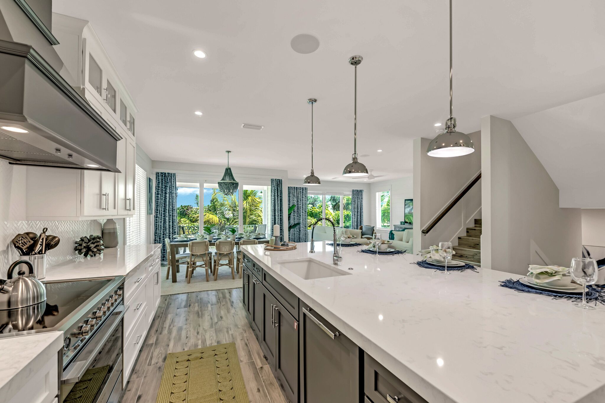 A modern kitchen with a large island, built-in appliances, and a dining area with a view.