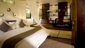 Een slaapkamer met een bed, nachtkastjes, een spiegel en een kledingkast.