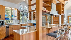 Una cucina moderna con mobili in legno, un'isola centrale e sgabelli da bar.