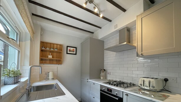 Cozinha moderna com bancada de mármore, eletrodomésticos de aço inoxidável e janela com vista.