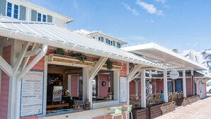 A seaside café with outdoor seating and a menu board.