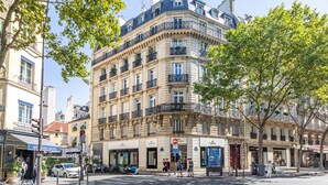 A multi-story hotel with a classic European architectural style, featuring balconies and large windows. - Appartement Haussmannien D'exception Coeur de Paris (Paris)