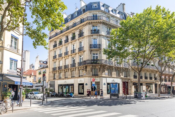 A multi-story hotel with a classic European architectural style, featuring balconies and large windows.