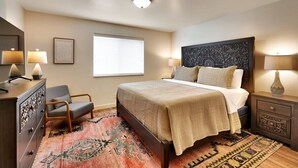 A bedroom with a bed, bedside tables, a chair, a dresser, and a window.