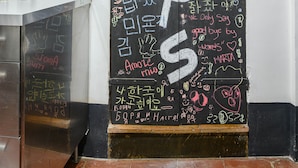 A blackboard with various writings and drawings, including the word "steps" prominently displayed.