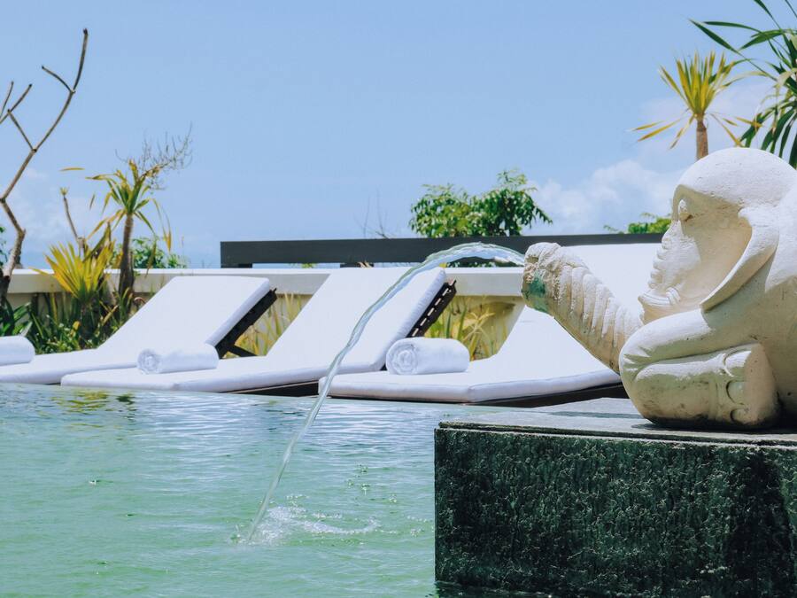 Una piscina al aire libre, sillones reclinables de piscina