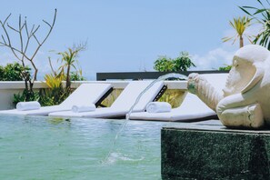 A pool area with lounge chairs and a statue. - Allia Residence Nusa Dua (Nusa Dua)