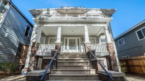 A two-story house with a front porch, a staircase leading to the entrance, and a number '1515' above the door.