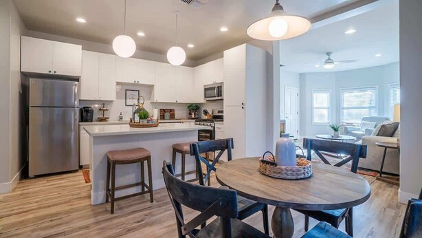 A modern kitchen with white cabinets, stainless steel appliances, and a central island with seating.