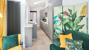 En moderne stue med sofa, sofabord og udsigt til køkkenet.