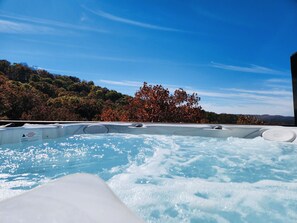 A hot tub with a warning sign, surrounded by trees and a clear sky. - 4Bdr Secluded! Hot Tub, Pool Table, & Spectacular Views. (Holiday Island)