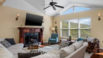 Smart-tv, eldstad, ett bordtennisbord och böcker