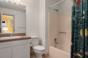A bathroom with a white sink, toilet, and bathtub.