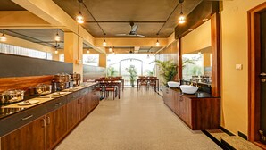 A modern kitchen with a long counter, multiple pots, and a view to the outside. - Worldtree Suites Manyata (Bengaluru)