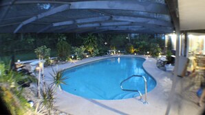 Una piscina con borde curvo, rodeada por una zona techada.