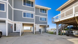 A multi-story residential building with a garage and a covered outdoor area.